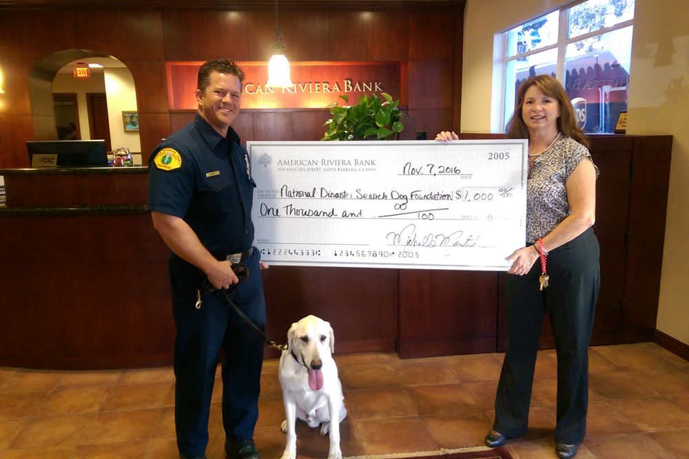 Riley & Eric Gray accept a check from American Riviera Bank
